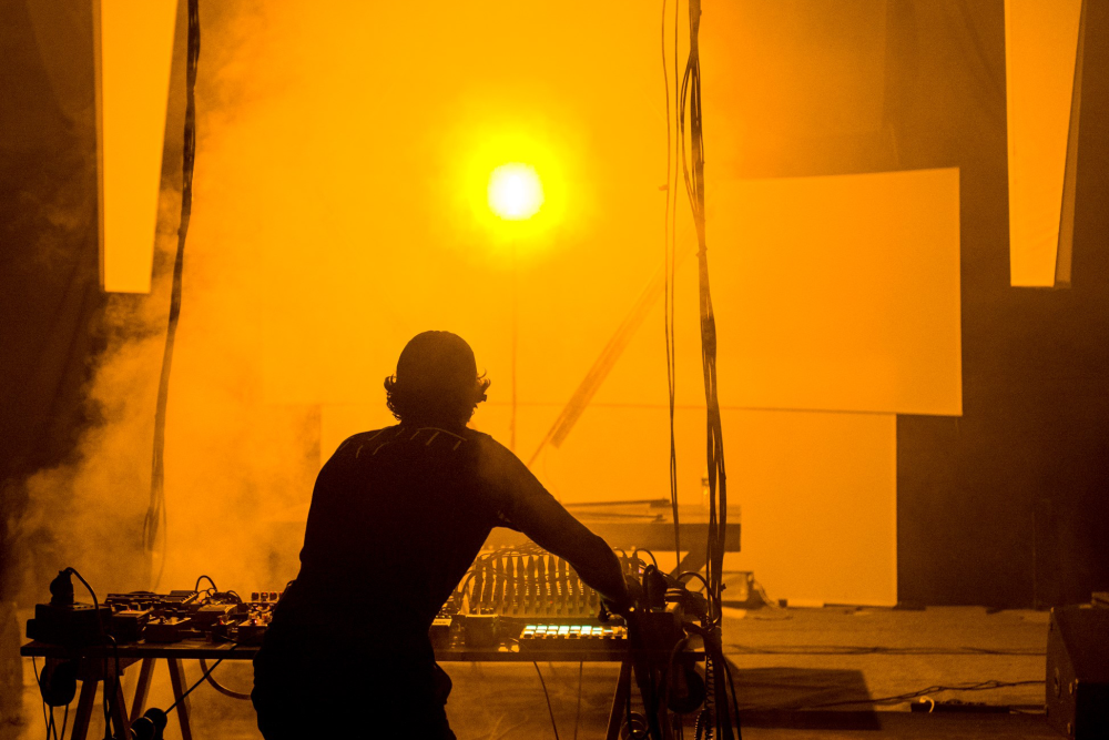 Silhouette d'une personne de nuit avec une lumière orange en fond